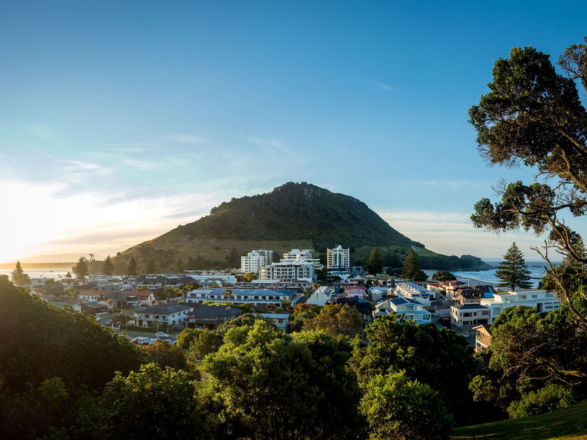 View of Mount Maunganui and nearby coastal town at sunrise
